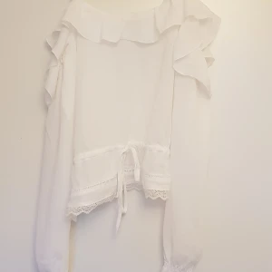 Off shoulder-top - Superfin off shoulder-top med linne-band och långa ärmar. I skirt tyg med små virkade spetsdetaljer och dragsko i midjan på framsidan. Endast använd en gång, inga fläckar, nyskick. Pris exkl frakt. Hämtas på Lilla Essingen alt mötas upp på Fridhemsplan.
