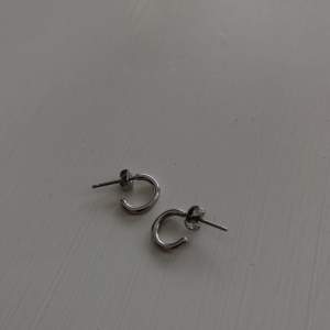 Fina örhängen från edbllad, små ringar. Nickelsäkra örhängen i rostfritt stål. Aldrig andvända.
