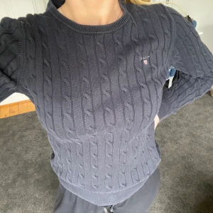 Gant kabelstickad  - Välanvänd men fint skick! Kanske något urtvättad. Jätteskön att ha på sig. . Osäker om den e svart eller mörkblå. Strl s