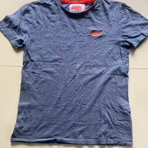 Superdry T-Shirt - Hej! Säljer denna mörkblåa/gråa superdry t-shirten. Den är rätt använd men har inga märkbara flaws. Nypris: 500kr, Mitt pris: 140kr. Köparen står för frakt, kan även mötas upp för att lämna över plagget👍