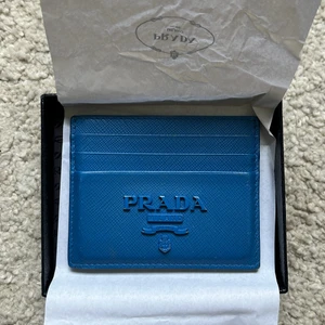 Prada Korthållare - Blå Prada korthållare, dustbag och orginallåda ingår. Inköpt 2020. Lite använd, men inga synliga skador/repor.