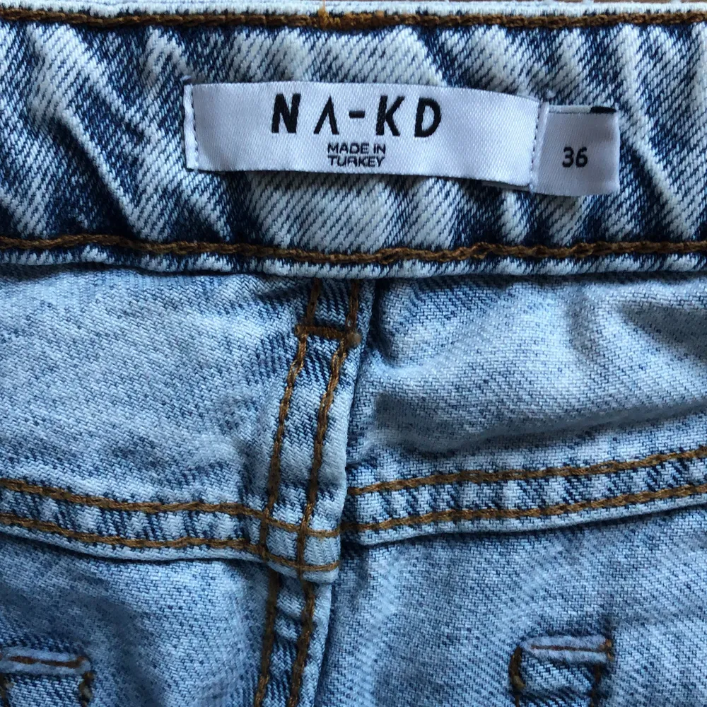 Högmidjade jeans från NA-KD med hål på knäna. Rak model. Är 167cm och jeansen slutar vid ankeln. Storlek: EU 36                                    Betalningssätt: Swish. Jeans & Byxor.