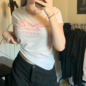 Hollister t-shirt 💓 - En fin vit t-shirt från hollister med namnet i rosa glitter 💕 Använd ett par gånger men i jättefint skick. Köparen står för frakt