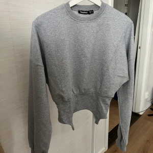 Långärmad tröja - Grå tröja, köpt förra året på Boohoo. Använd 2-3 gånger endast så i väldigt fint skick. Kan skicka bilder med den på till den som är intresserad :)