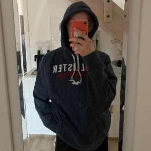 Hollister Hoodie - säljer denna marinblå/grå hoodie från hollister, köpt på deras butik i new york city för ca 500kr 💙 väldigt mysig, lite oversized på mig som vanligvis är en S/M 😇 fint skick då den inte är jätteanvänd 🫶🏼