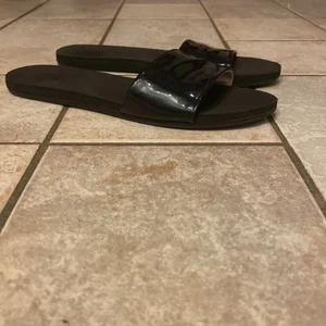 Lackade tofflor - Lackade tofflor ifrån hm. Några slitningar i sulan fram.     Storlek  36. Hör av er för mer information/bilder. Köparen står för ev frakt.