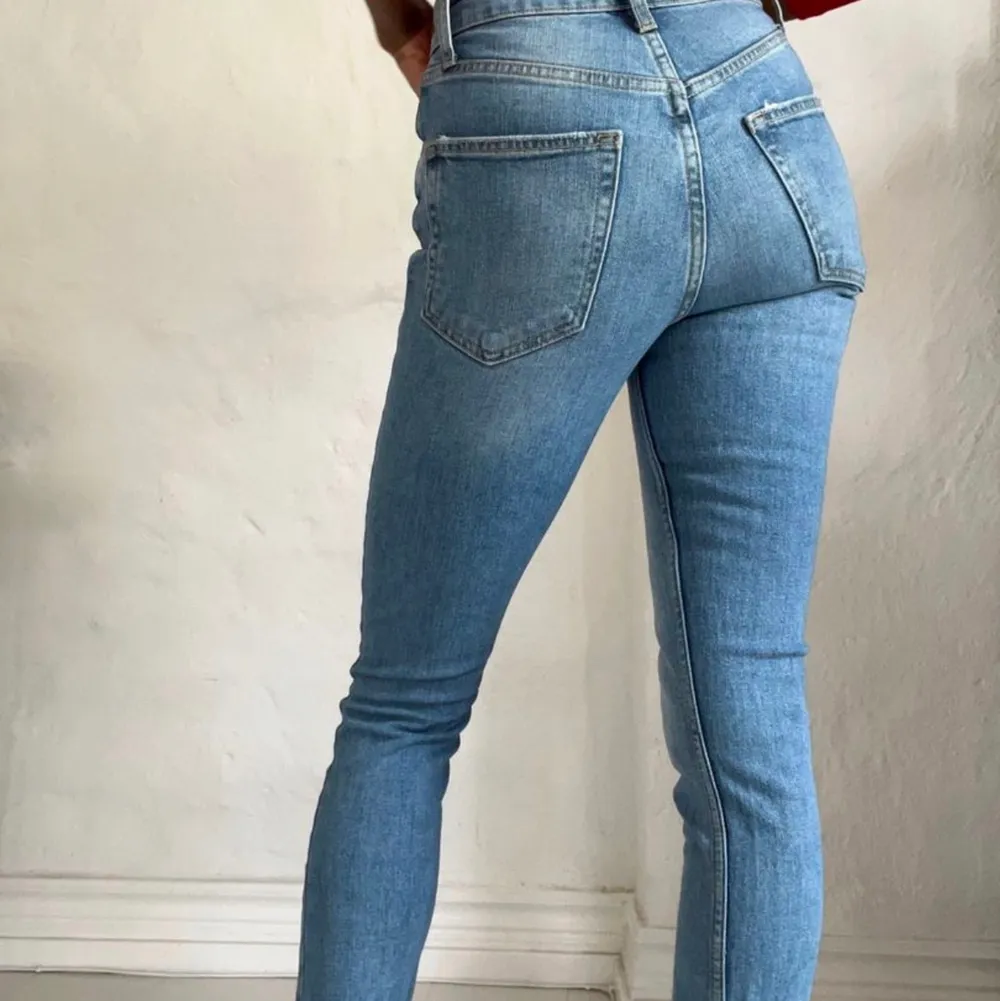 Ett par blåa sienna jeans från ginatricot med fransar på benen i storlek 34. Jeans & Byxor.