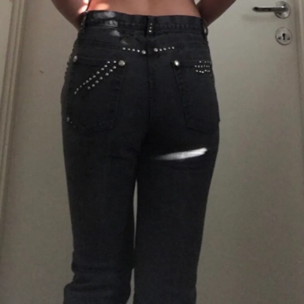 Väldigt 2000 tals svarta jeans som är kortare vid ankeln, med silver detaljer på övre delen av jeansen. Jeans & Byxor.