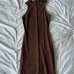 Brun långklänning  - Brun långklänning som tyvärr ej passade mig och kunde ej lämna tillbaka. Klänningen är från Prettylittlething i storlek 38. Skulle dock vilja påstå att den passar personer som bär S eller XS för klänningen har nästan inget stretch.