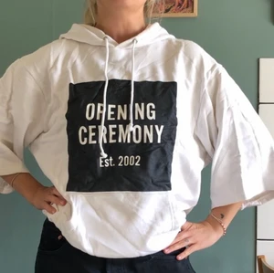 Hoodie vit från Opening Ceremony strlk s - Vit Hoodie med vida lite kortare ärmar. Tryck på bröst och rygg. Storlek small. Fint begagnat skick. 