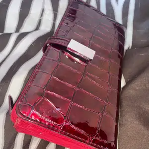 Röd fin plånbok med många olika fak