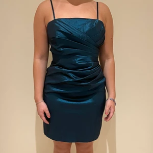 Cocktailklänning från Balina - Superfin cocktailklänning från Balina som passar alla typer av event! Klänningen har en jättefin passform som framhäver kurvor fint. Färgen på klänningen är petrol som är en mättat blå med dragning åt grönt. Den är i storlek 40 men känns verkligen mer som 36/38. Klänningen är i nyskick.