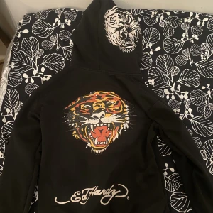 Asfet edhardy tigerhoodie💯 - Säljer min älskade edhardyhoodie då jag behöver pengar🥲💯 Hoodien är i storlek L, hoodien i sig är i perfekt skick däremot saknas rhinestones + den går it att zippa upp, (men går säkert att laga på skräddare) Den är asfet unzipped tho så vem bryr sig🤣🤣 