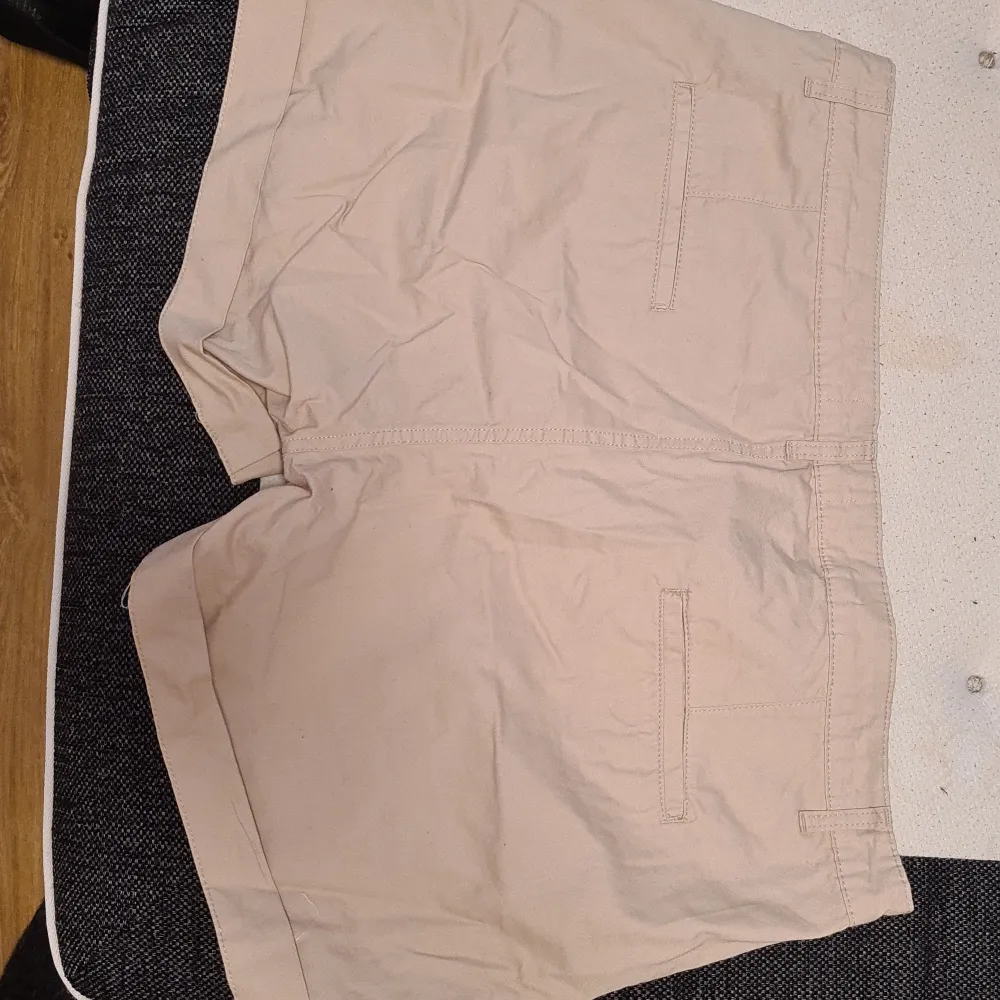 Ett par snygga korta shorts som är beigea. Inte använda då de är förstora för mig.  Lite skrynkliga för har legat i garderoben. Shorts.