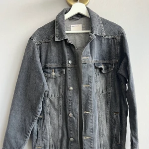 Asos jeansjacka - Mörkgrå jeansjacka, lite baggy i modellen. Köpt för flera år sedan men inte använt många gånger. Fint skick. Det är inte en tunn jacka, den är i rejält jeanstyg.