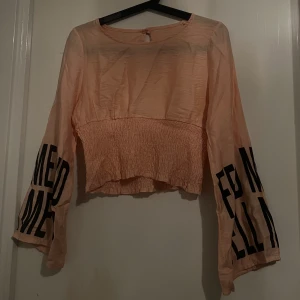 Långärmad tröja  - En rosa långärmad tröja men sitter lite löst på slutet av armarna. Sitter jätte fint på