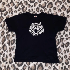 svart baby-tee  - Så söt svart baby tee med tryck av en tiger tror jag💓🐯 den går precis där magen slutar på mig, står inte storlek men skulle säga S😙 