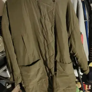 En militärgrön jacka från H&m i storlek S som har avtagbar ytterjacka. Denna jacka är i nyskick. Knälång, oversize. 