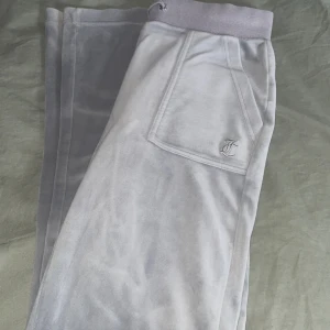 Juicy Couture - Ett par juicy byxor i st Xs färgen quite gray. Köpta på hemsidan men det vart fel storlek därav har de bara legat i garderoben. Hör av er vid frågor. fotar ej bild med de på pga att de är för små och vill inte töja ut de. Har defekt i snöringen.