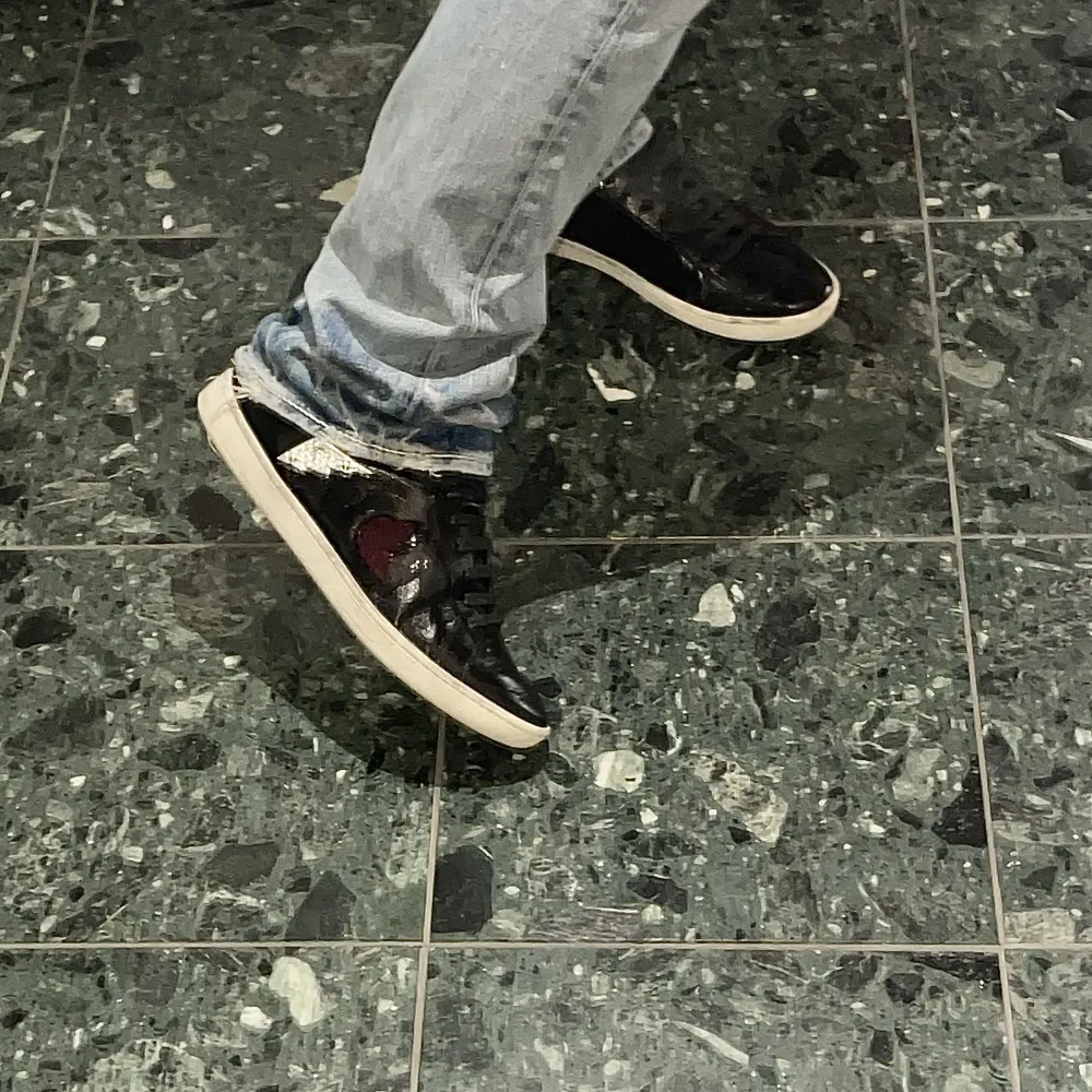 Säljer dessa svarta glansiga skor från Yves Saint Laurent med detaljer på sidorna (höger fot: rött hjärta och blixt, vänster fot: svart hjärta och nitar). Nypris ligger runt 6000kr.  Storlek 39🙌 Boxen är borta men dustbag medkommer🖤🖤. Skor.