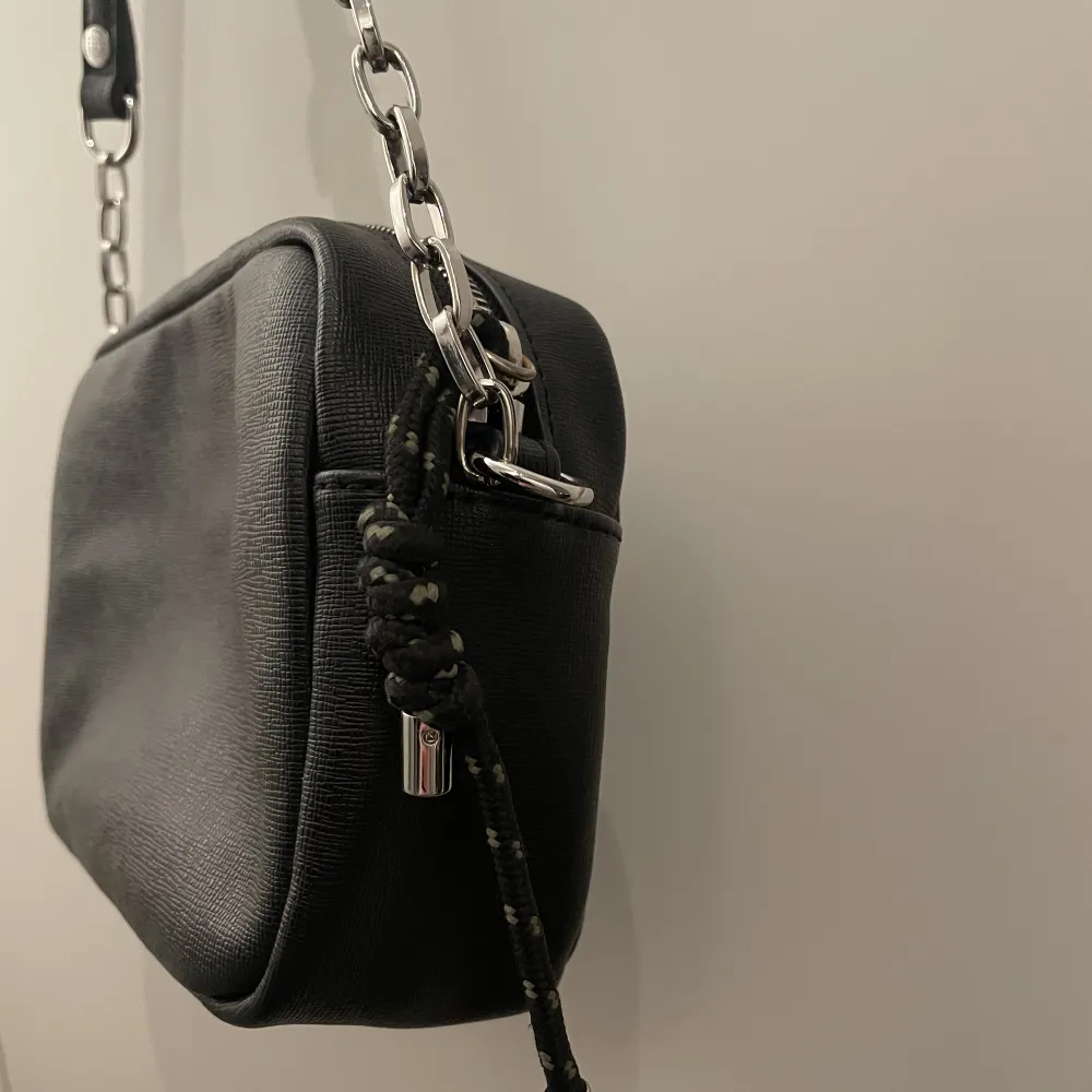 En Tommy Hilfiger handväska i gott skick. Har använt den ett fåtal gånger. Den är svart med coola detaljer. . Accessoarer.