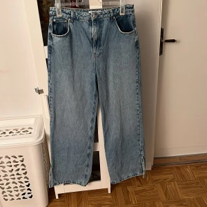 Blå jeans - Blå högmidjade jeans med slit i foten från NAKD. Använd fåtal gånger.