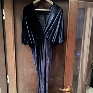 Lång klänning i sammet från Stylein - Stylein: Lång mörkblå klänning i sammetslent material (98% polyester, 2% elastan) strl M (passar 36-38)  Använd vid ett tillfälle  Ej skråmor eller förändringar i material