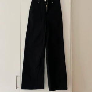 Svarta vida byxor H&M 34 - Svarta vida högmidje jeans från hm, storlek 34. Endast använda en gång så i nyskick!