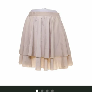 Superfin beige kjol från NA-KD!  - Jättefin beige volangkjol från NA-KD i strl 38. Svalt skönt material. Liten dragkedja i sidan. Aldrig använd. Nyskick! 