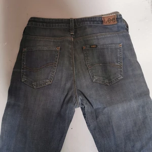 Lee jeans strl W27 L33 - Lee jeans med hål vid knät. Fint skick. 