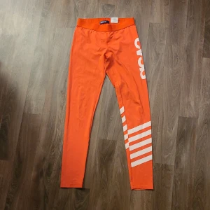 Träningstights - Svea - I mycket gott skick. Endast använda en gång. Perfekt till träning och att bara ha på sig hemma. Färgen är röd-orange
