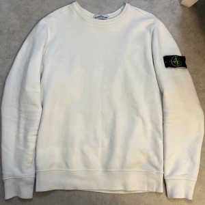 Vit Stone island tröja - Säljer en skit snygg stone island tröja. Säljer den pga att kommer den inte till så mycket användning. Använd fåtal gånger, inga skador, inga hål eller något liknande. Köparen står för frakt. Jag kan givetvis gå ner i pris vid snabb affär.