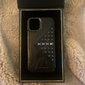 Fint skap från Ideal of Sweden - Säljer mitt super fina skal från Ideal of Sweden. Skalet är svart med svart silvriga nitar på, den  har även ett inbyggd korthållare. Se bild 3. Perfekt skick. Skalet är aldrig använt och endast testat! Säljer pga den inte passade min mobil! 