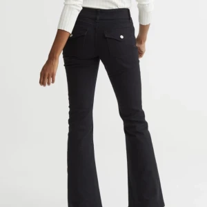 Långmidjade bootcut jeans - Lågmidjade utsvängda jeans nertill och med knappar på fickorna! Säljer pga att de är för små för mig. Helt slutsålda på hemsidan.   Ca 38 cm tvärs över midjan