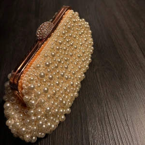 Pärl väska  - Fin pärl handväska. Kommer med både handtag och en kedja för axeln. Den är i supper bra skick. Prefekt full fester. Frakt tillkommer. 