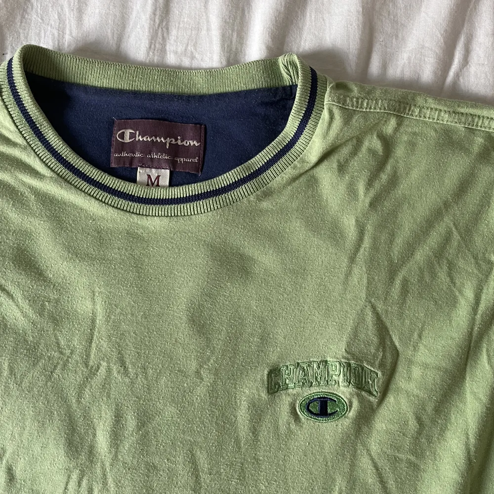 ljusgrön tshirt med mörkblåa detaljer från champion. väldigt bra skick, storlek M. köparen står för frakt. . T-shirts.