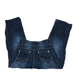 Baggy jeans - Ett par mörkblåa baggy jeanse med detaljer vid fickorna och slitningar vid fötterna