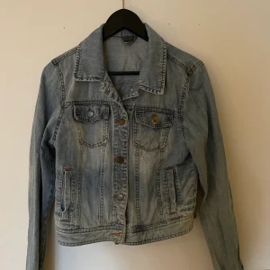 Cool jeansjacka i olika nyanser av blå - Vintage jeansjacka. Säljer då den inte kommer till användning, fint skick och tvättad. Snygg med skiftande blå färg. Storlek L men väldigt liten modell, figursydd och passar snarare S/M