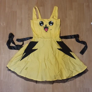 Klänning cupcake cult - Klänning i storlek M av cupcake cult. Med motiv av något som ser ut som pokemonen Pikachu. Med fickor!  Puffig klänning som knappt är använd.  Orginalpris: 500kr