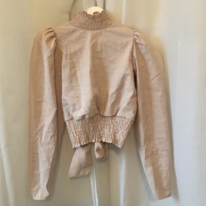 Blus med öppen rygg! - Snygg blus med öppen rygg! Jättefin färg! Lite trasig där man knäpper i ryggen men det fungerar ändå!