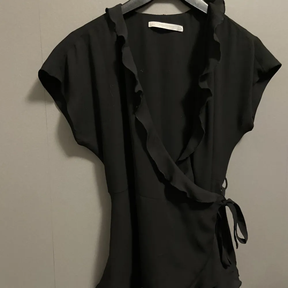 En svart blus/kofta med fina volanger och fin knytning Från Zara Säljer endast för att den är för liten Aldrig använd. Blusar.