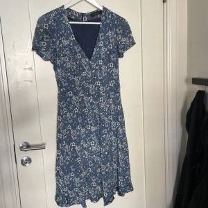 Blå blommig klänning - Säljer min älskade klänning då den tyvärr inte kommer till användning längre. Köppt secondhand men fortfarande väldigt fint skick! 