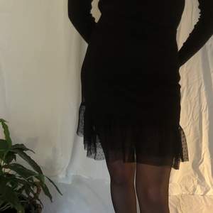 Svart kjol med söt volang. En svart underkjol + en lite längre i mest-tyg. Kort, högmidjad & tight modell.