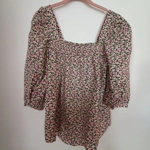 Blommig topp/blus  - Blommig blus/topp från H&M i stl M. Den har lite puffärm. Helt ny och oanvänd.  Frakt ingår i priset.