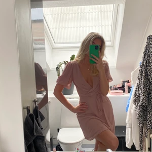 Rosa klänning  - En perfekt rosa miniklänning med puffiga armar samt knyte i midjan från Nelly.com. Klänningen har en urringning framtill samt en dragkedja på vänster sida. Jag bär storleken 34 ( Xs - S ). 