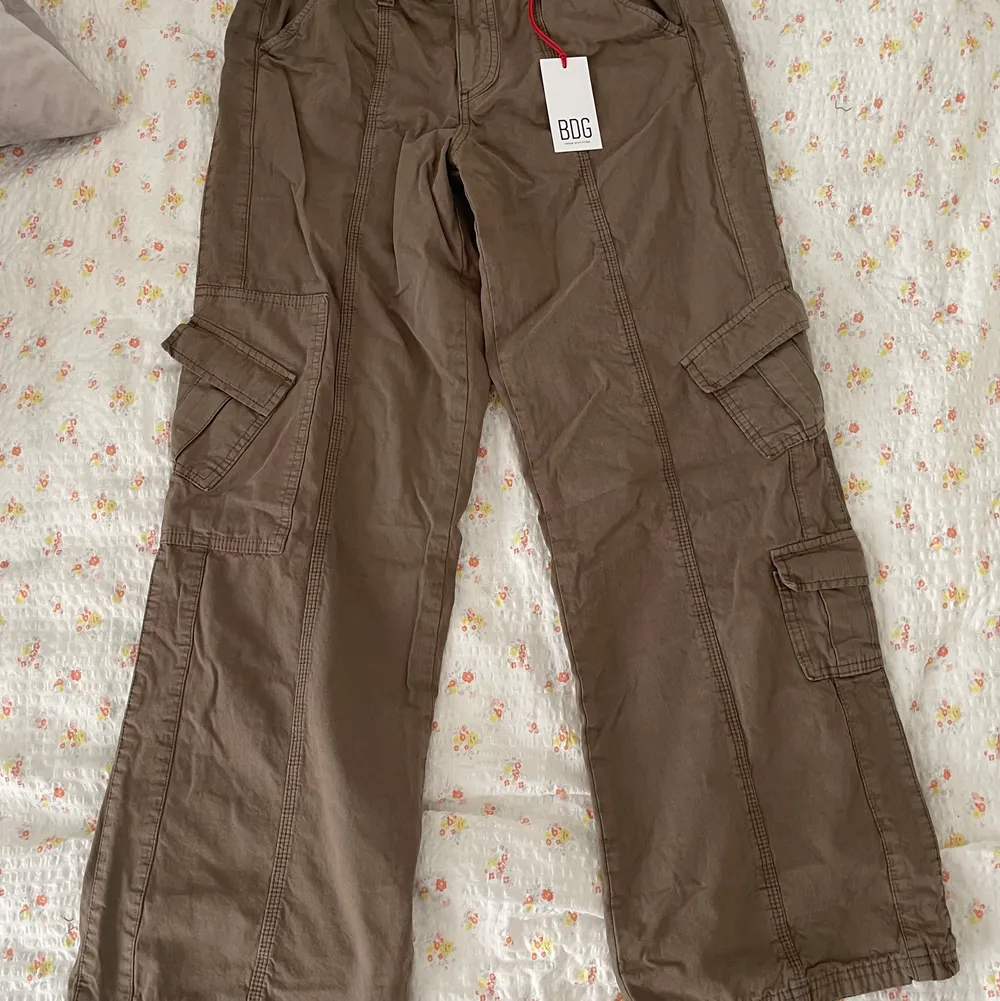 Säljer dessa helt nya Cargo pants från Urban Outfitters som aldrig kommit till användning, lapparna är kvar! Storlek 38! Låg midja! ☺️🌸. Jeans & Byxor.