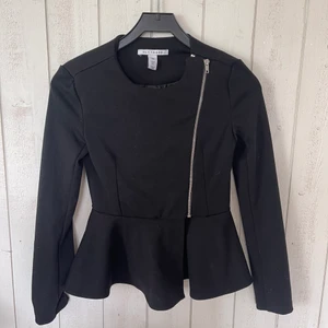 Nelly Svart jacka  - En svart figursydd jacka/ kofta med sne dragkedja och fina volanger nedtill. Tyget är mycket mjukt och den passar perfekt inför alla tillfällen. 🌸