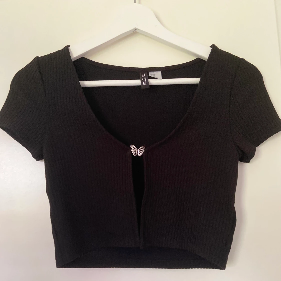 Topp med knapp av silver fjäril