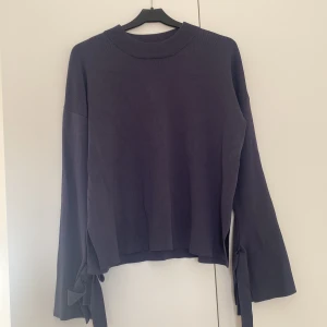 Långärmad tröja med rosetter - Blå långärmad tröja med slits och rosetter på ärmarna. Storlek S och i fint skick:) Från Wera Stockholm!