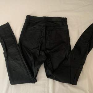 Högmidjade skinnbyxor (fake) i jeans liknande modell. Använda fåtal gånger men finns liten reva på ena knät men som inte är så synlig. Storlek 38